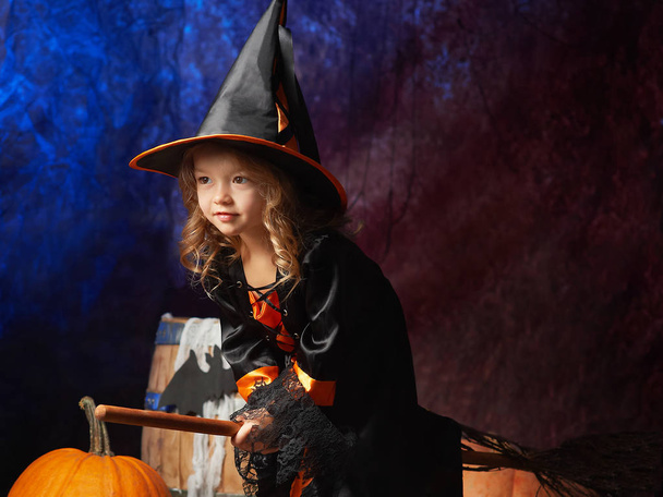 little girl in witch costume on a broom ready to fly  - Foto, Bild