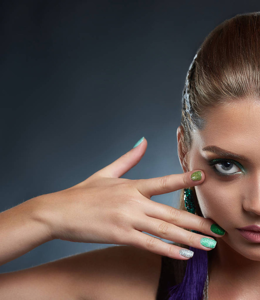 Brunette after beauty salon, with long violet earring showing shine manicure. - Foto, Bild