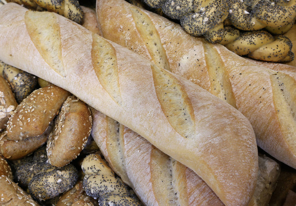 pieces of fresh bread in the bakery with fragrant loaves and bag - Photo, Image
