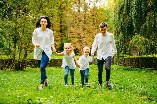 щаслива сім'я біжить в міському парку
 - Фото, зображення
