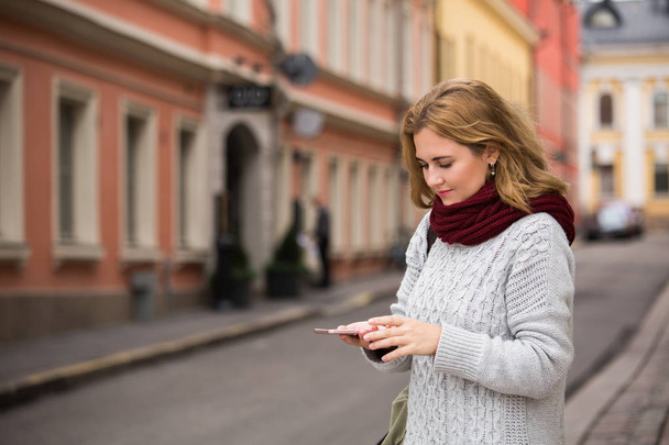 A woman with phone on a street - Фото, зображення