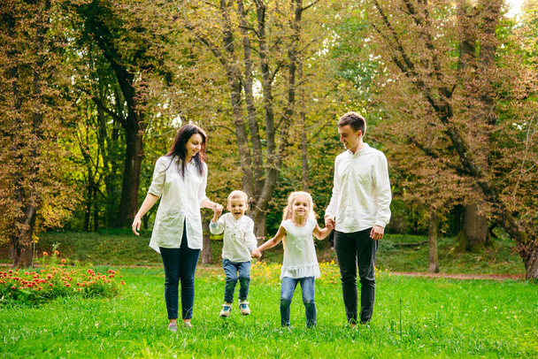 familia feliz corriendo en el parque de la ciudad
 - Foto, Imagen
