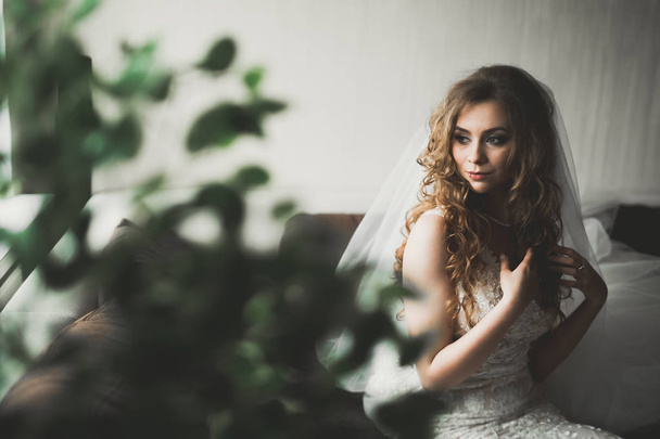 Luxury bride in white dress posing while preparing for the wedding ceremony - Фото, изображение
