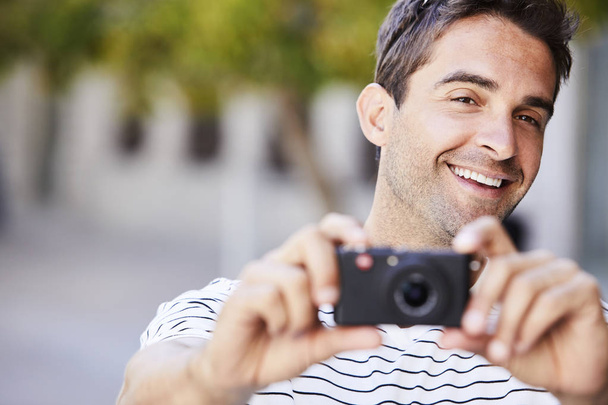 Handsome guy smiling with a camera - Фото, изображение