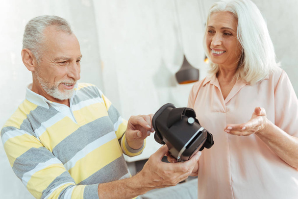 Positive aged coupel holding virtual reality glasses - Zdjęcie, obraz