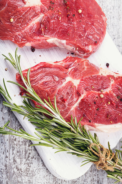 Raw fresh beef steak on a white cutting board - 写真・画像