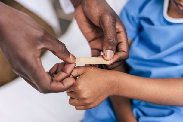 african american doctor putting adhesive plaster - 写真・画像
