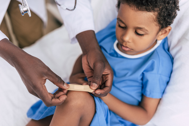 african american doctor putting adhesive plaster - Photo, Image