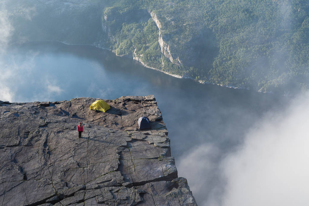 Chica en la roca Preikestolen, Noruega
 - Foto, Imagen