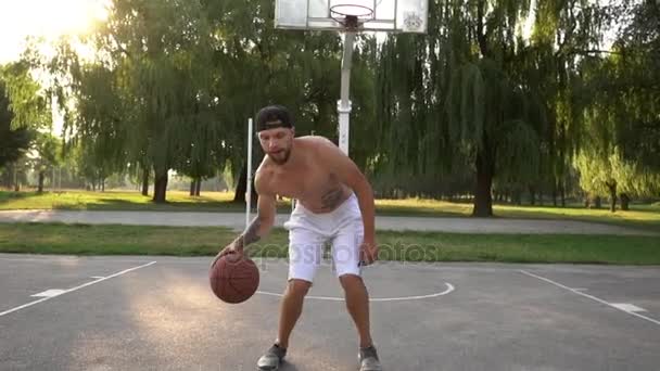 Man tries to beat the opponent while playing basketball - Filmati, video