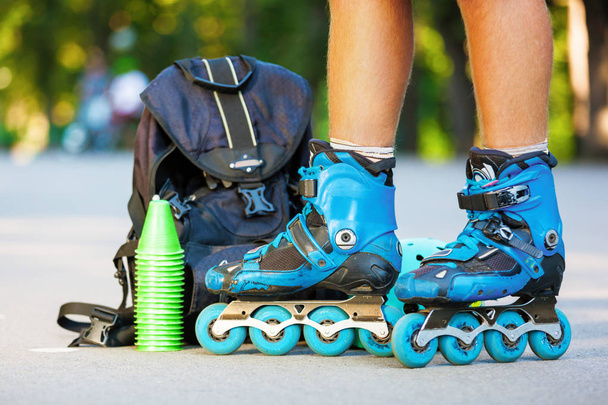 Closeup photo of legs in blue inline skates standing. - Fotó, kép