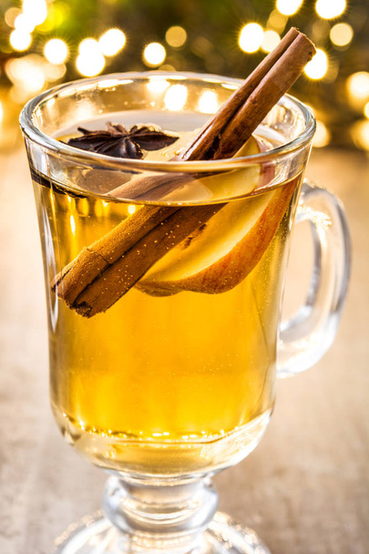 mulled cider in glass, ornaments and christmas light on wooden table - Photo, Image