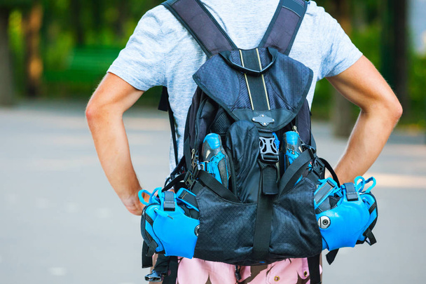 Young male roller skater with roller backpack - shoot from behin - Foto, Imagen
