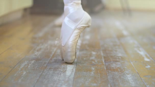 A ballerina shows a classic warm-up. Close the ballerina's feet when she practiced the exercises on the glasses. 4K. - Кадры, видео