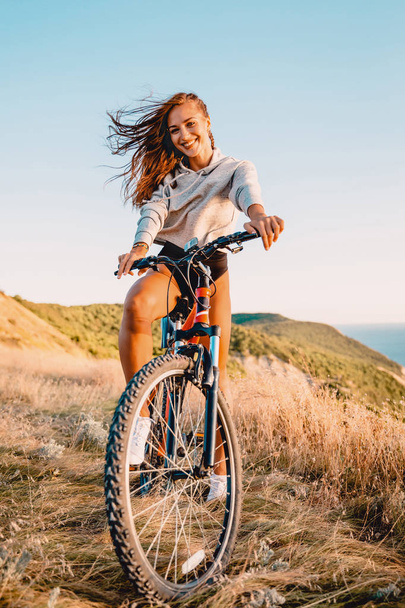 vrouw met fiets ontspannen - Foto, afbeelding