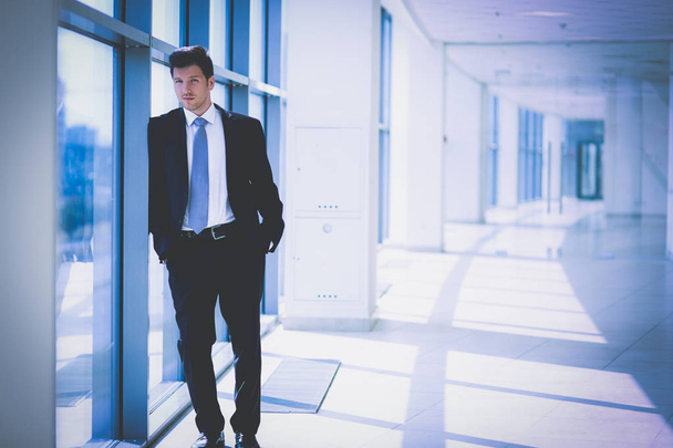 Портрет бізнесмена, що стоїть біля вікна в офісі
 - Фото, зображення