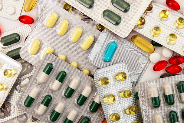 Σωρός από ιατρική δισκία και τα χάπια με φουσκάλες διαφορετικά χρώματα  - Φωτογραφία, εικόνα