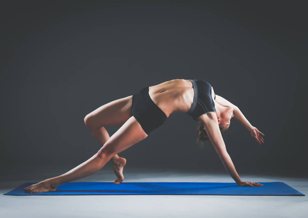 Portrait of sport girl doing yoga stretching exercise - 写真・画像