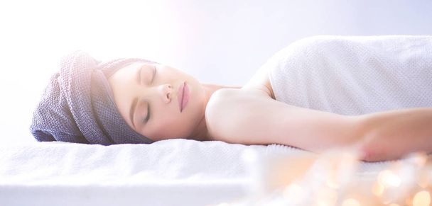 Young woman lying on a massage table,relaxing with eyes closed - Photo, image
