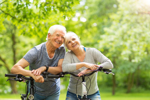 pareja de ancianos montar bicicletas en el parque - Foto, Imagen