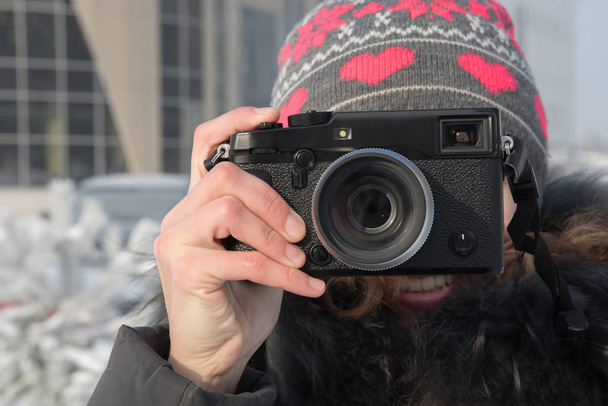 Fille en chapeau avec appareil photo prenant des photos en hiver
 - Photo, image
