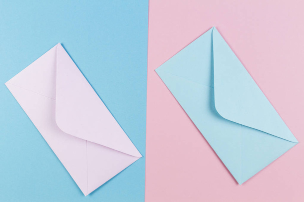 Pink and blue envelopes on colored pink and blue background. Top view. - Fotografie, Obrázek