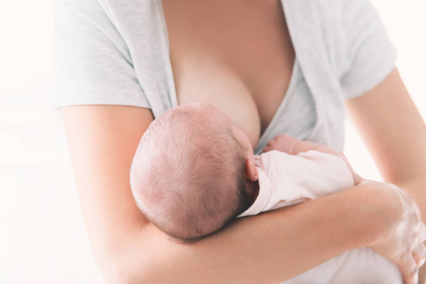 Mother breastfeeding newborn baby at home.  - Фото, зображення