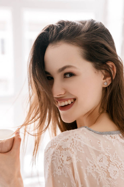 S úsměvem mladá žena s šálek ranní kávy - Fotografie, Obrázek