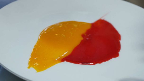 Rozmazání jam na talíři. Dva druhy džemu, na desce potřené špachtle - Fotografie, Obrázek