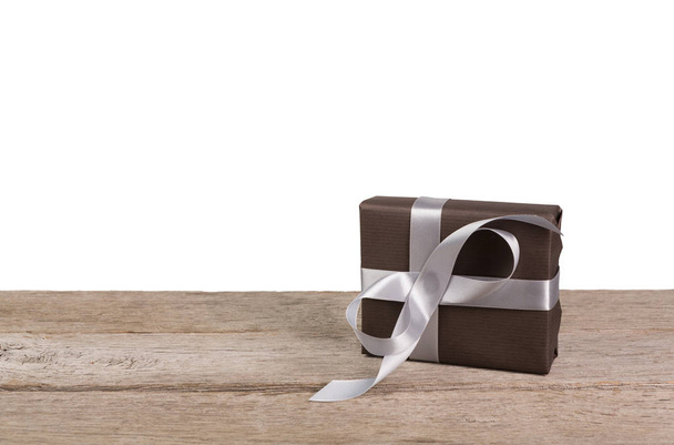 Новорічна подарункова коробка, загорнута в папір на дереві на білому тлі
 - Фото, зображення