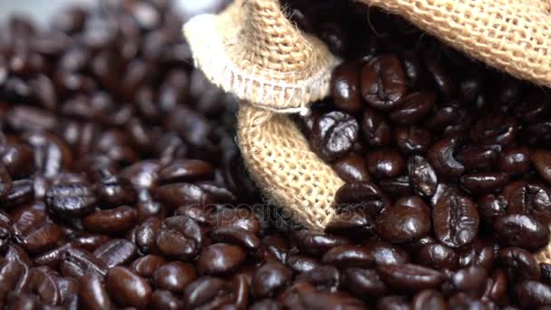 Palone ziarna kawy Spill z jutowej torby - Materiał filmowy, wideo