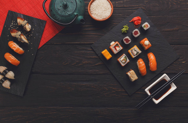 Sushi and rolls background, frame on black, top view. - 写真・画像