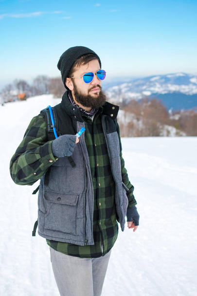 Bearded hiker walking on snow covered mountain - Fotó, kép