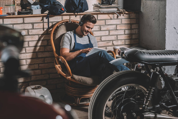 mechanic with tablet in repair shop - Foto, afbeelding