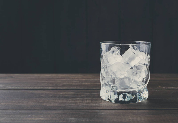Склянка з кубиками льоду на темному фоні
 - Фото, зображення