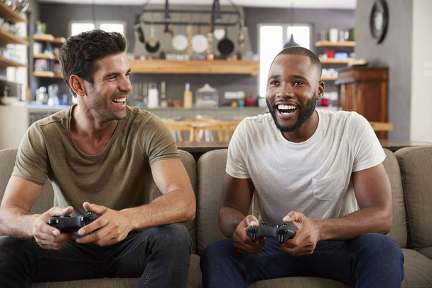Amigos masculinos jugando videojuego
 - Foto, Imagen