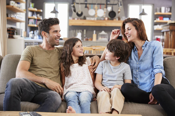 Happy Family Sitting On Sofa In Lounge Talking Together - Photo, Image