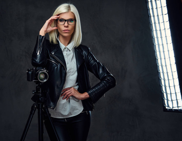 Blond photographer female holds camera  - 写真・画像