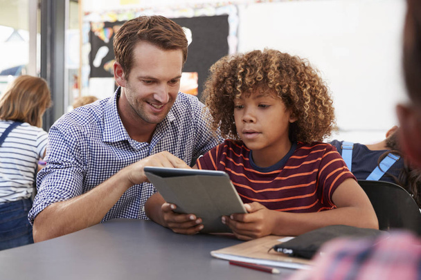 Teacher and schoolboy using tablet  - Photo, Image