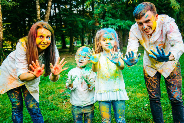 familia feliz pálido con pinturas holi en el parque de la ciudad
 - Foto, imagen