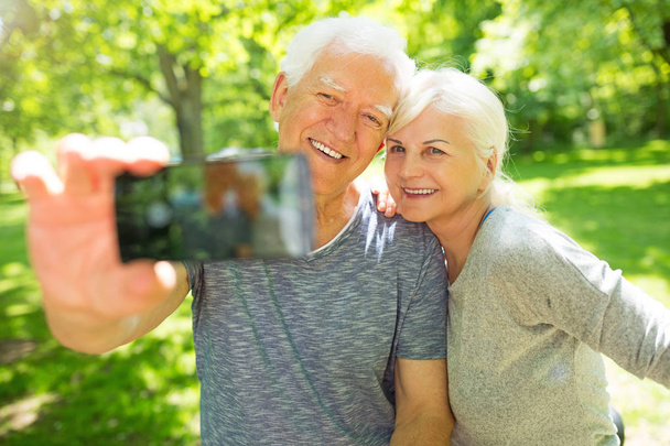 Senior couple with bicycles taking selfie - Foto, Imagen