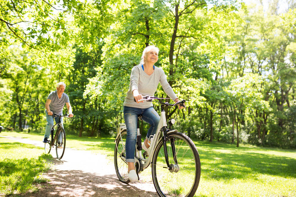старшие пары на велосипедах в парке - Фото, изображение