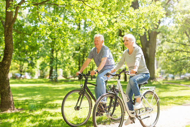 pareja de ancianos montar bicicletas en el parque - Foto, imagen