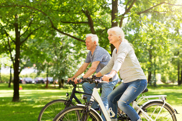 Senior Couple Riding Bikes In Park - Фото, изображение
