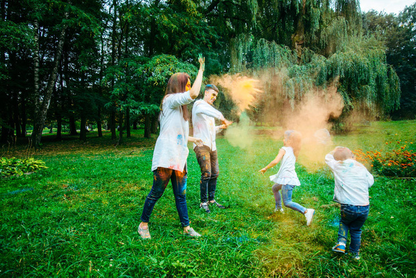 Szczęśliwa rodzina paly farbami holi w parku miejskim - Zdjęcie, obraz