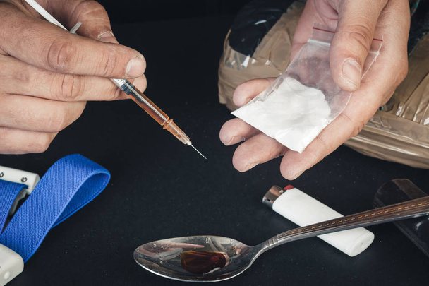 Miesten kädestä kiinni kämmenessä muovipussi jauhe cocai
 - Valokuva, kuva