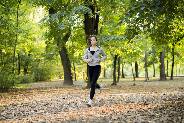 Fit woman jogging in park - 写真・画像