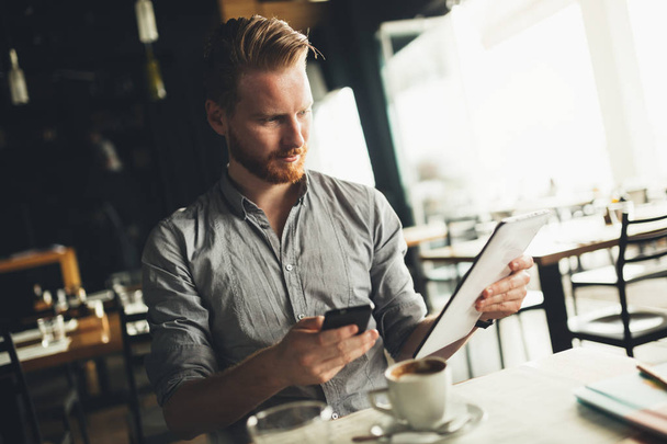 Businessman using tablet in cafe - Foto, Bild