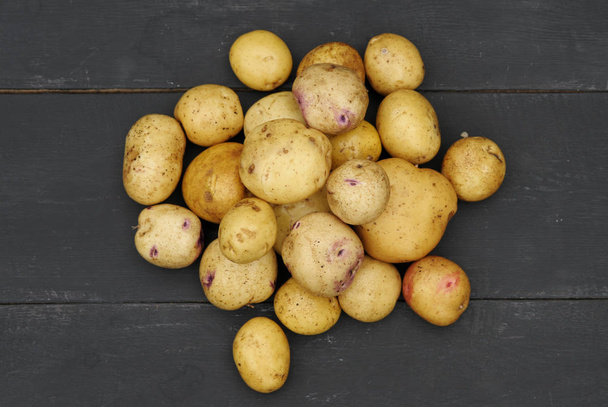 potatoes on a wooden table - Φωτογραφία, εικόνα
