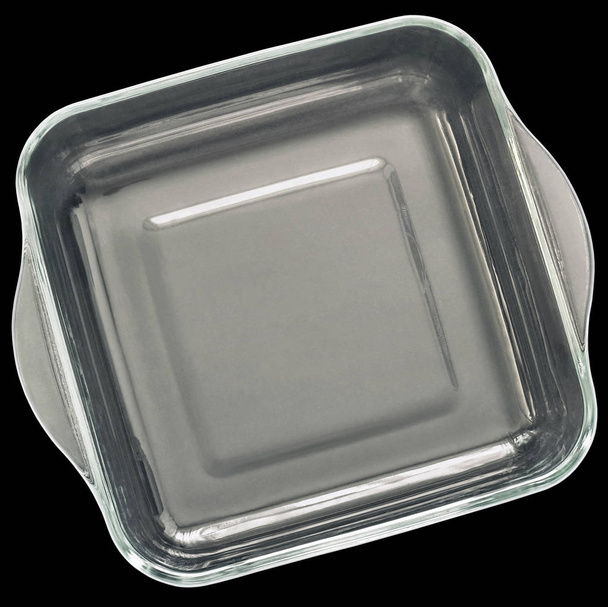 Teglia di cottura in vetro quadrato arrotondato con maniglie curve isolate su sfondo nero
 - Foto, immagini